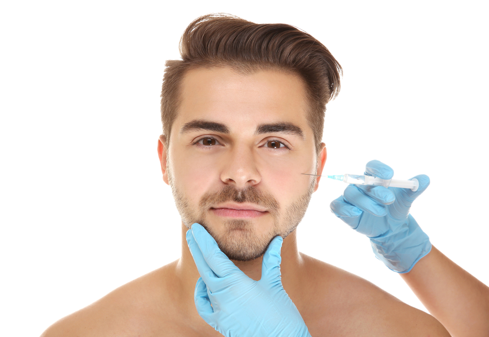 Homem recebendo aplicação de botox durante procedimento de harmonização facial masculina